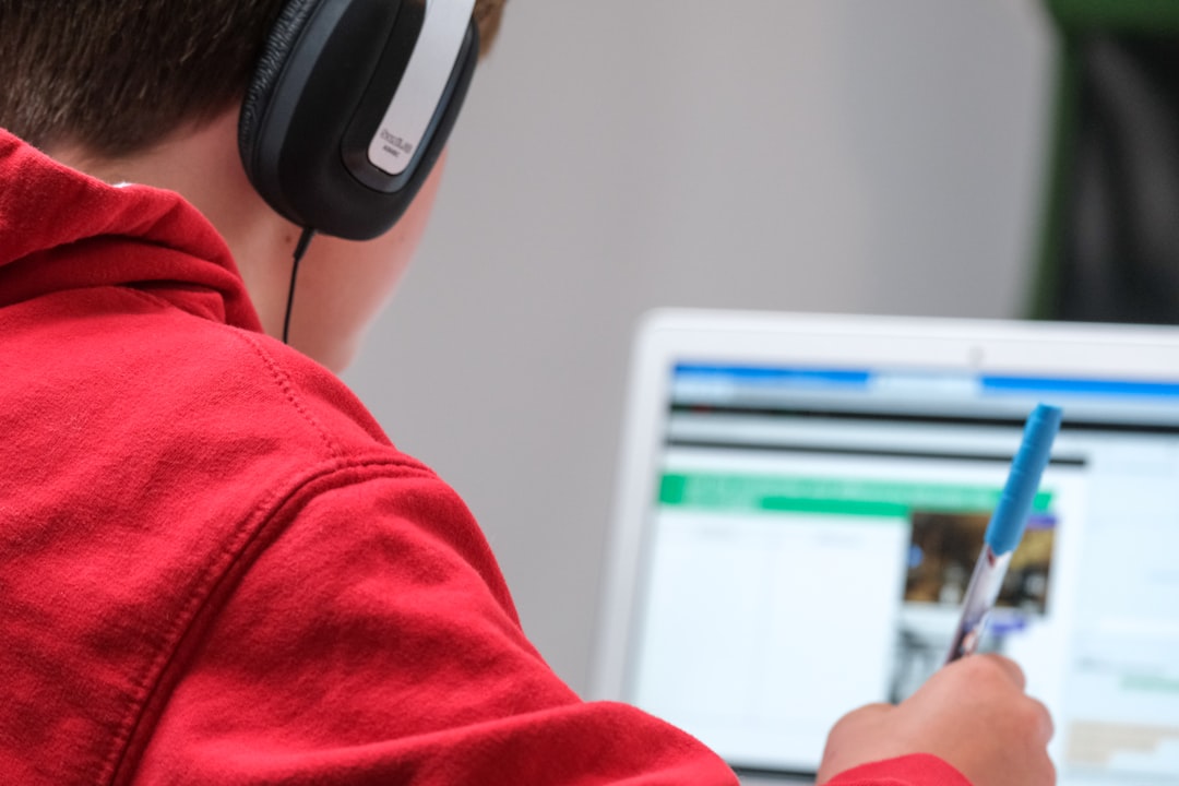 Person learning from online video tutorial with headphones