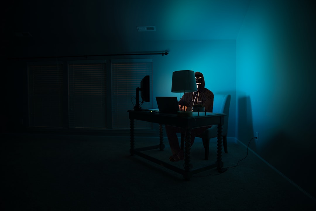 A developer desk at night with a laptop terminal and a phone used as a chat channel